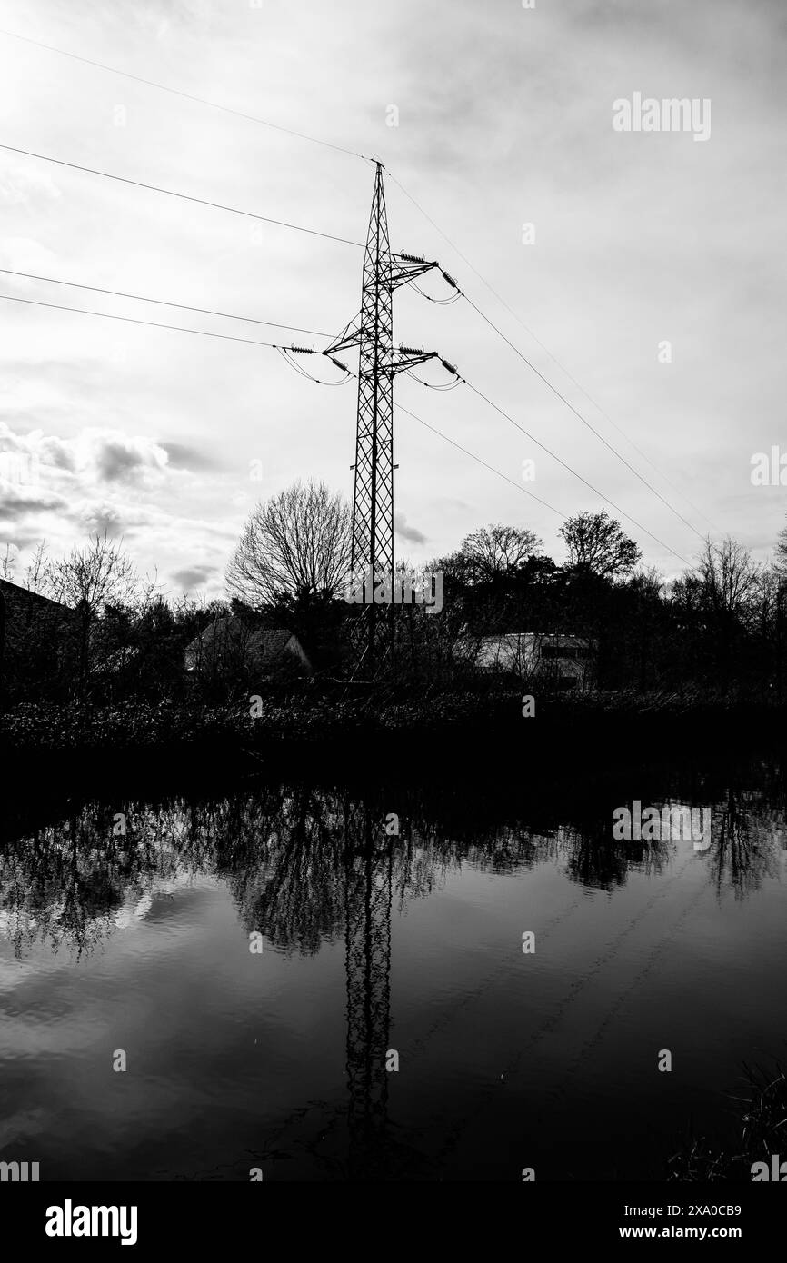 Une échelle de gris d'un poteau électrique à côté du canal à Schoten, Anvers, Belgique Banque D'Images