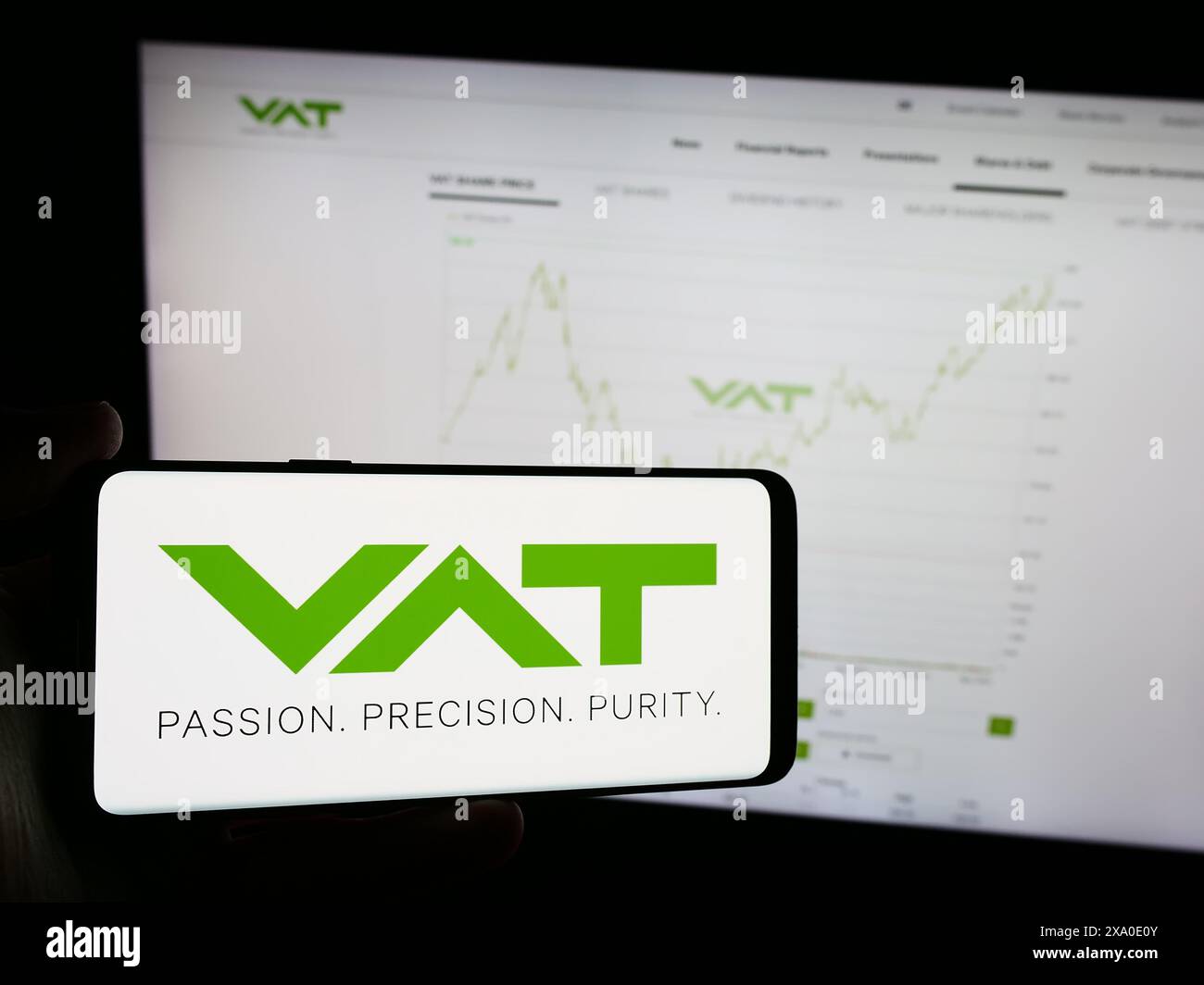 Personne tenant le téléphone portable avec le logo de la société suisse de technologie du vide VAT Group AG devant la page Web de l'entreprise. Concentrez-vous sur l'affichage du téléphone. Banque D'Images