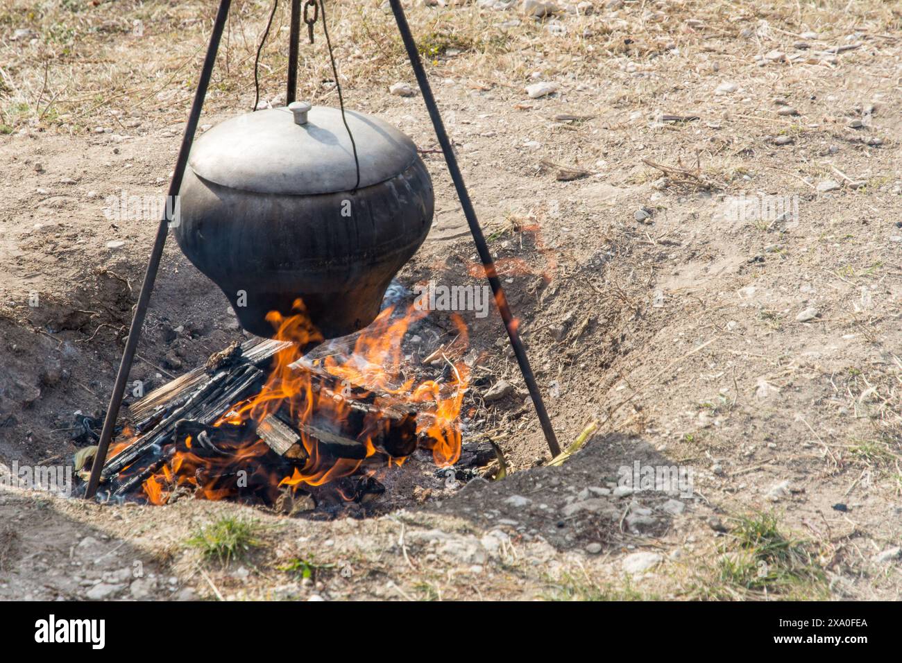 cuisson en vieille fonte sur trépied au-dessus du feu Banque D'Images