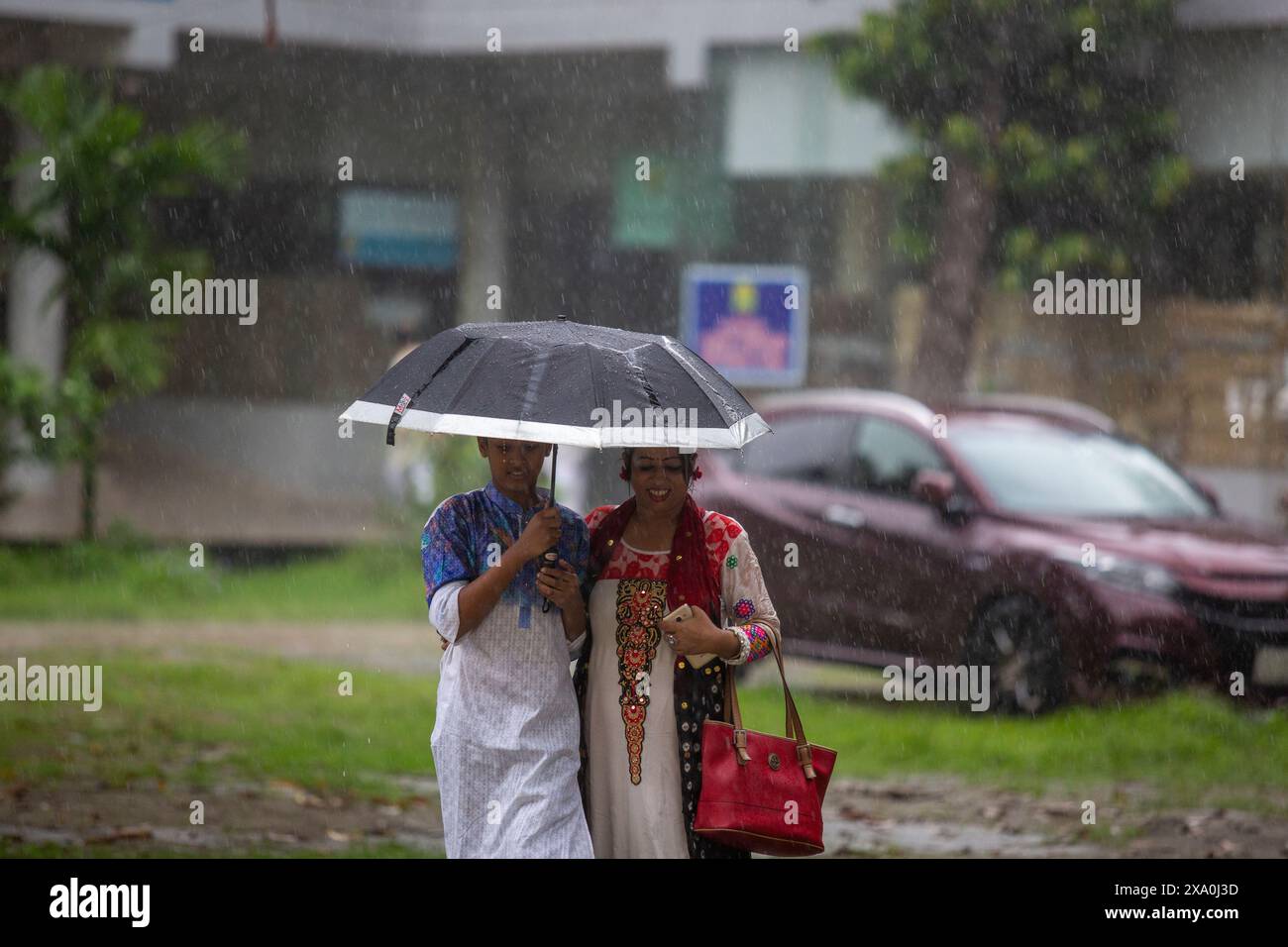 Une mère et son fils appréciant la pluie à Dhaka, au Bangladesh. Banque D'Images