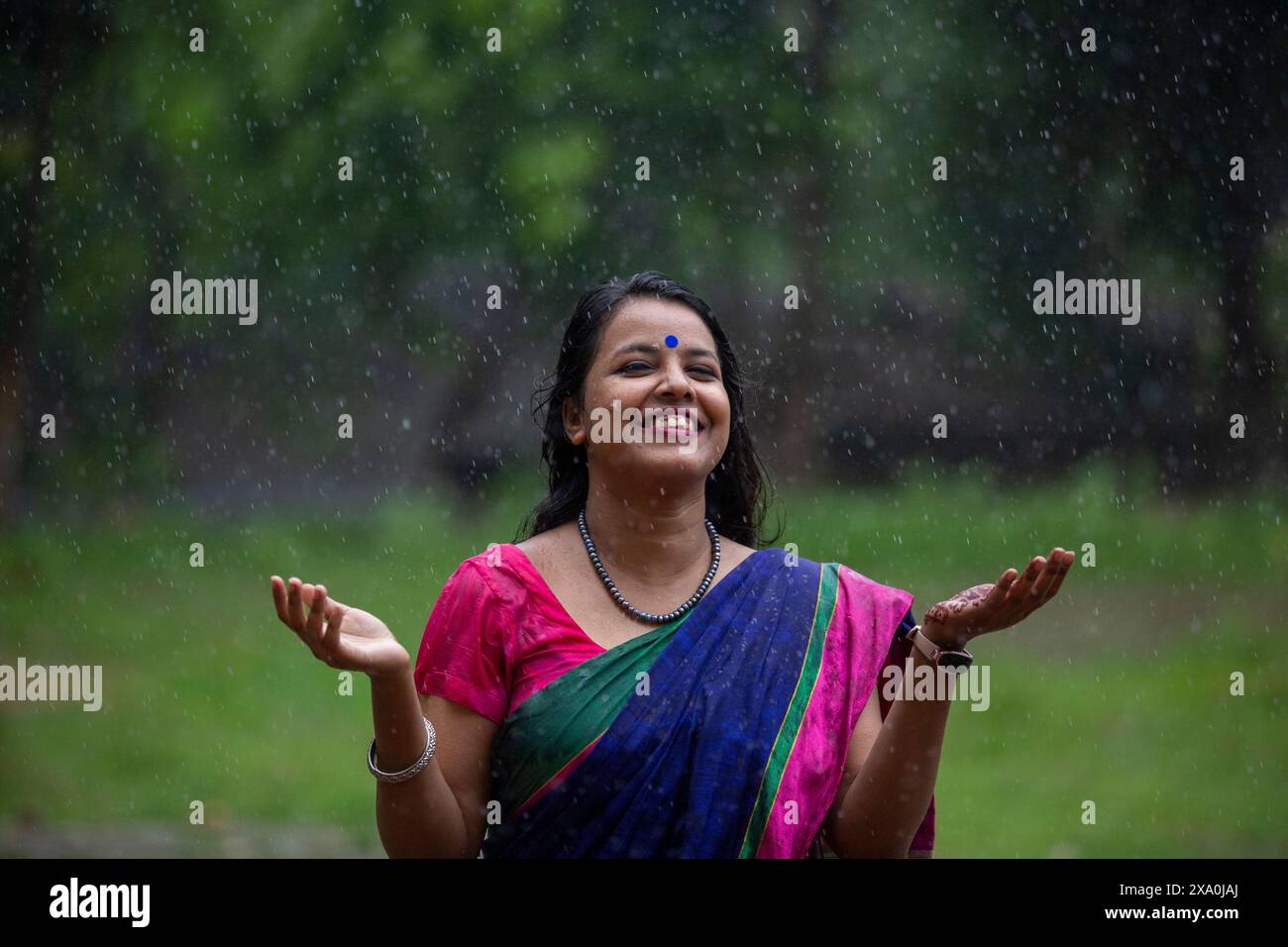 Une femme qui profite de la pluie à Dhaka, au Bangladesh. Banque D'Images