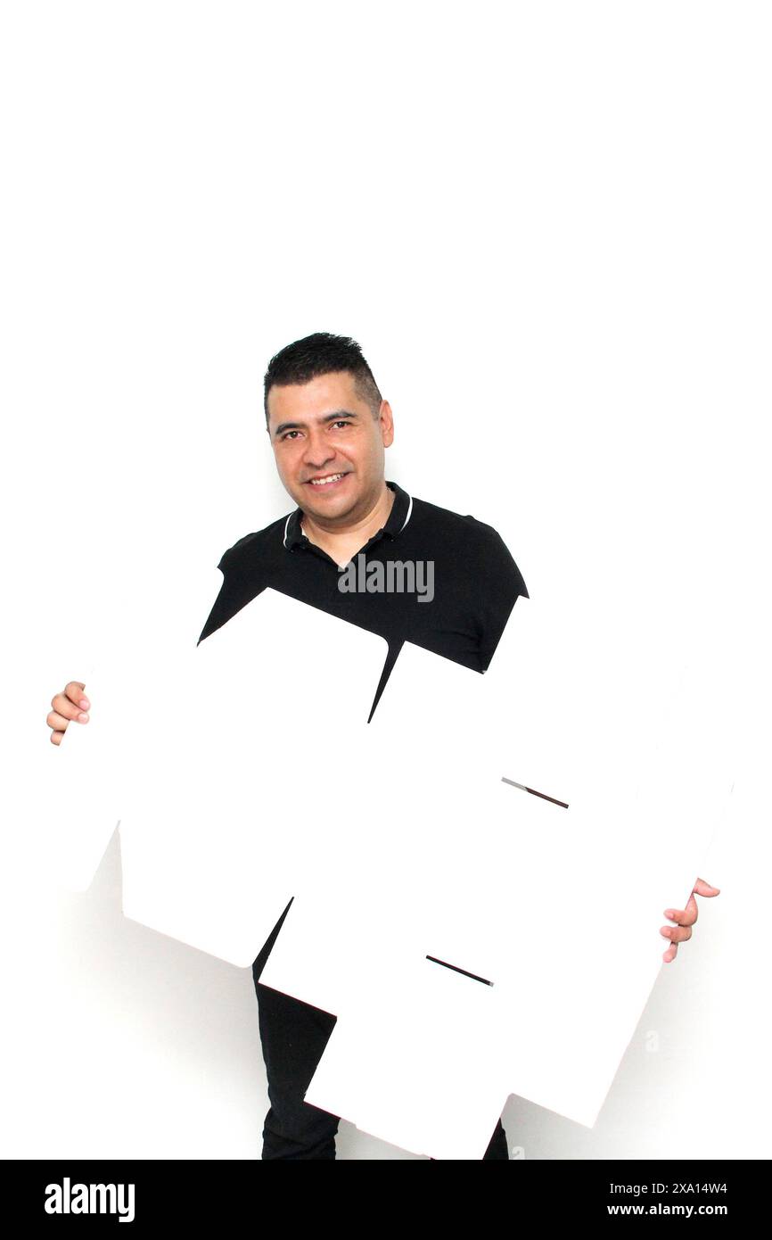 Homme adulte Latino à peau foncée assemble une boîte en carton suivant les instructions concentrée et attentive Banque D'Images Homme adulte Latino à peau foncée assemble une boîte en carton suivant les instructions concentrée et attentive Banque D'Images