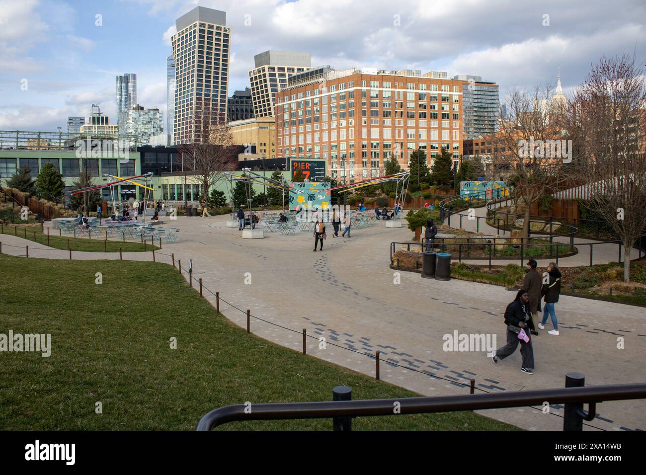 Une scène de parc avec plusieurs personnes et de l'herbe verte luxuriante de chaque côté Banque D'Images