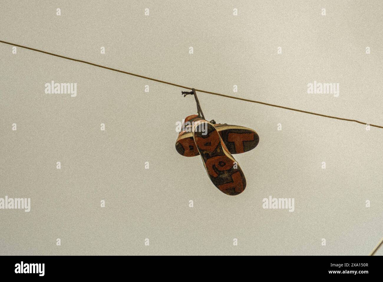 Une paire de chaussures accrochées à un fil téléphonique. Banque D'Images Une paire de chaussures accrochées à un fil téléphonique. Banque D'Images
