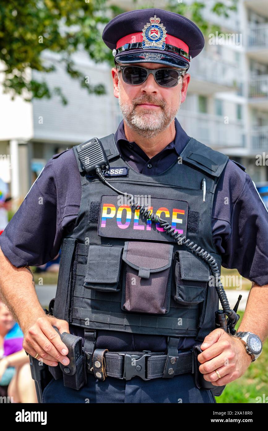 Police, portrait franc du défilé Pride policier portant les couleurs arc-en-ciel de la fierté, LGBT, LGBTQ+ mars agent de police de la police de la police provinciale de l'Ontario, London, Ontario, Canada Banque D'Images