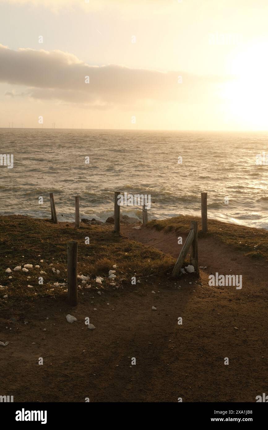 Le coucher de soleil illumine les vagues qui s'écrasent sur une rive rocheuse Banque D'Images