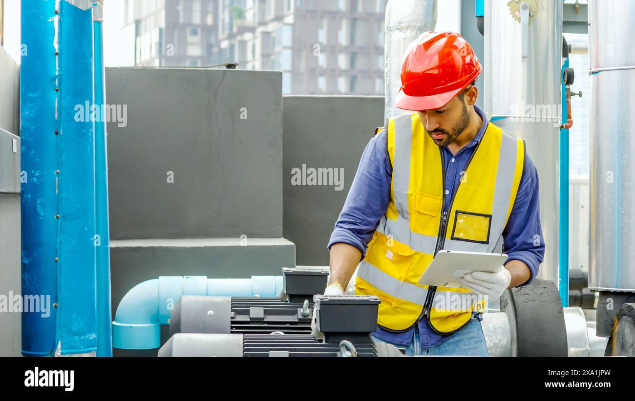 Un homme inspectant les tuyaux avec une planchette à pince à la main. Banque D'Images
