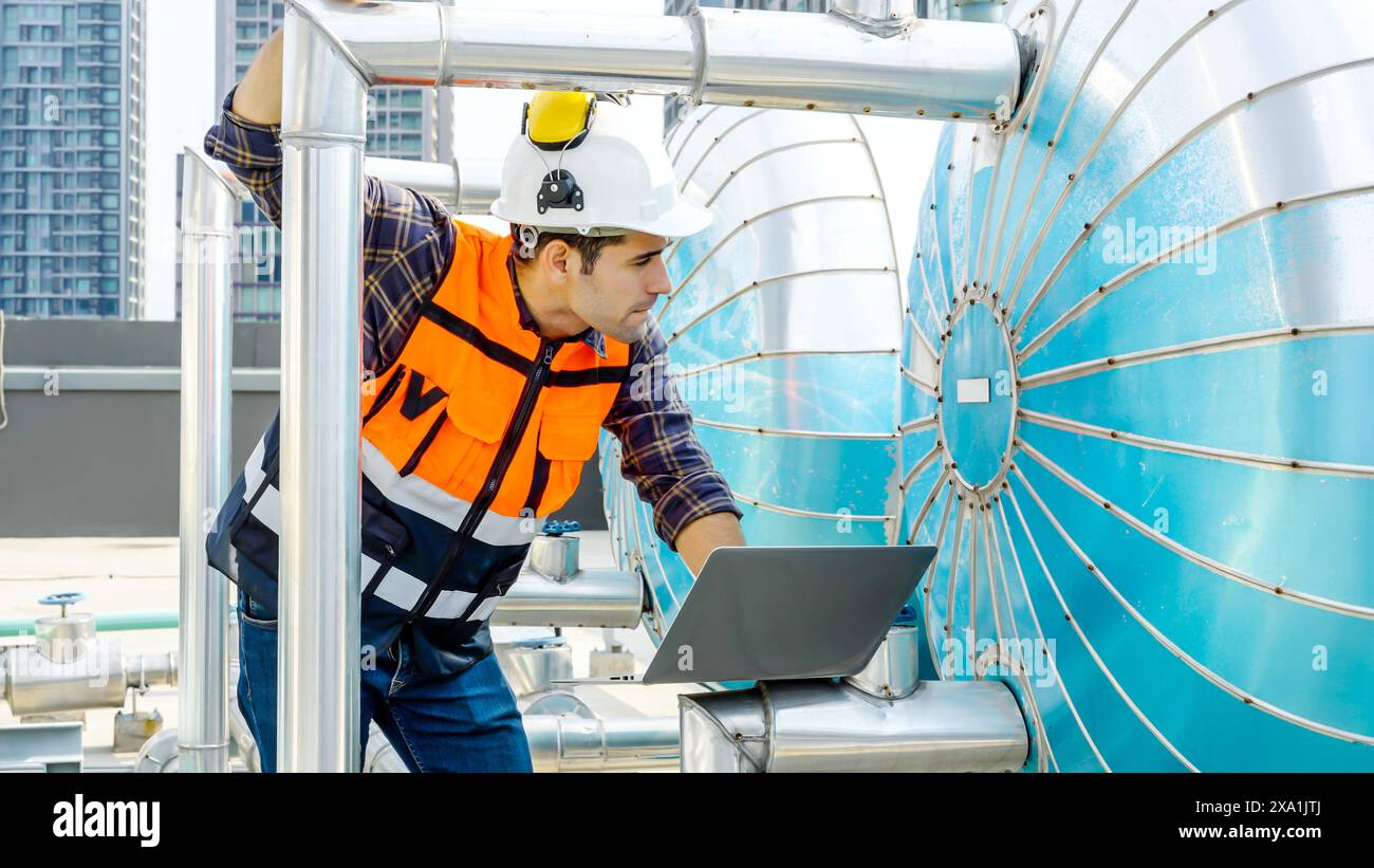 Un ingénieur utilisant un ordinateur portable sur un chantier de construction. Banque D'Images