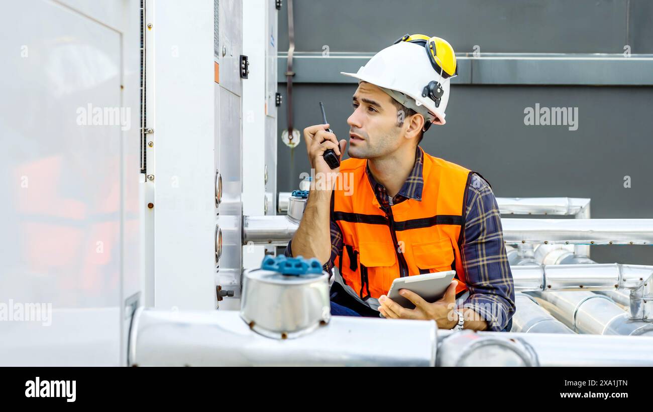 Un ingénieur parlant sur un talkie-walkie sur un chantier de construction. Banque D'Images