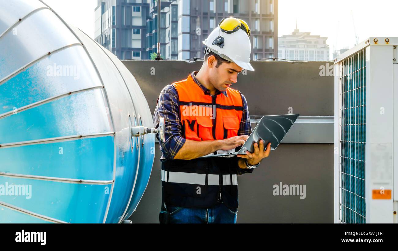 Un ingénieur utilisant un ordinateur portable sur un chantier de construction. Banque D'Images