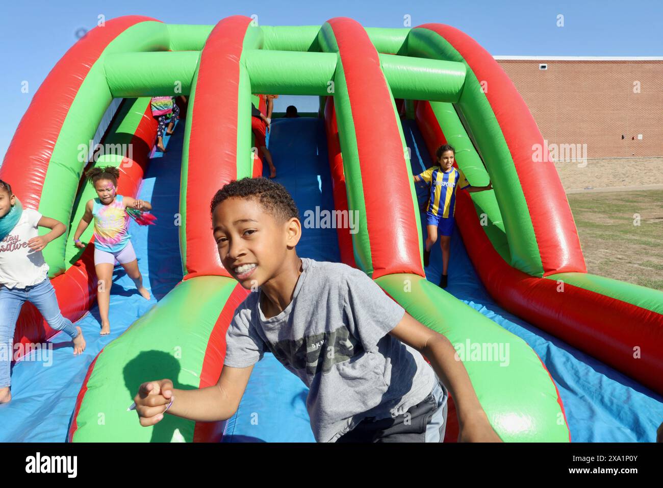 Un garçon debout sur un toboggan gonflable Banque D'Images