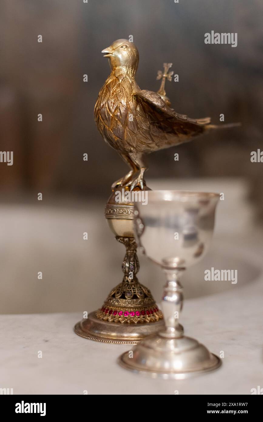 Un chrismarium arménien traditionnel en forme d'oiseau à côté d'un gobelet en argent Banque D'Images