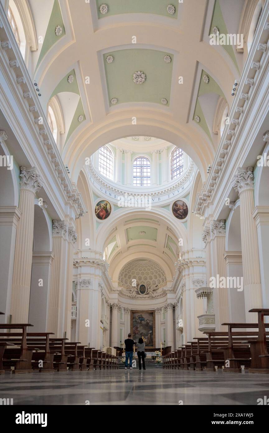 Un couple se promenant dans une grande cathédrale Urbino avec de hauts plafonds Banque D'Images