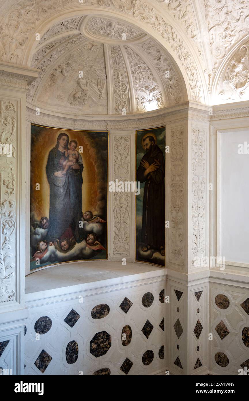 Une œuvre d'art sur le mur de l'église au-dessus de l'évier dans la chambre avec un travail artistique merveilleux à l'intérieur du palais ducal d'Urbino dans la province de Pesaro et Urbino Banque D'Images