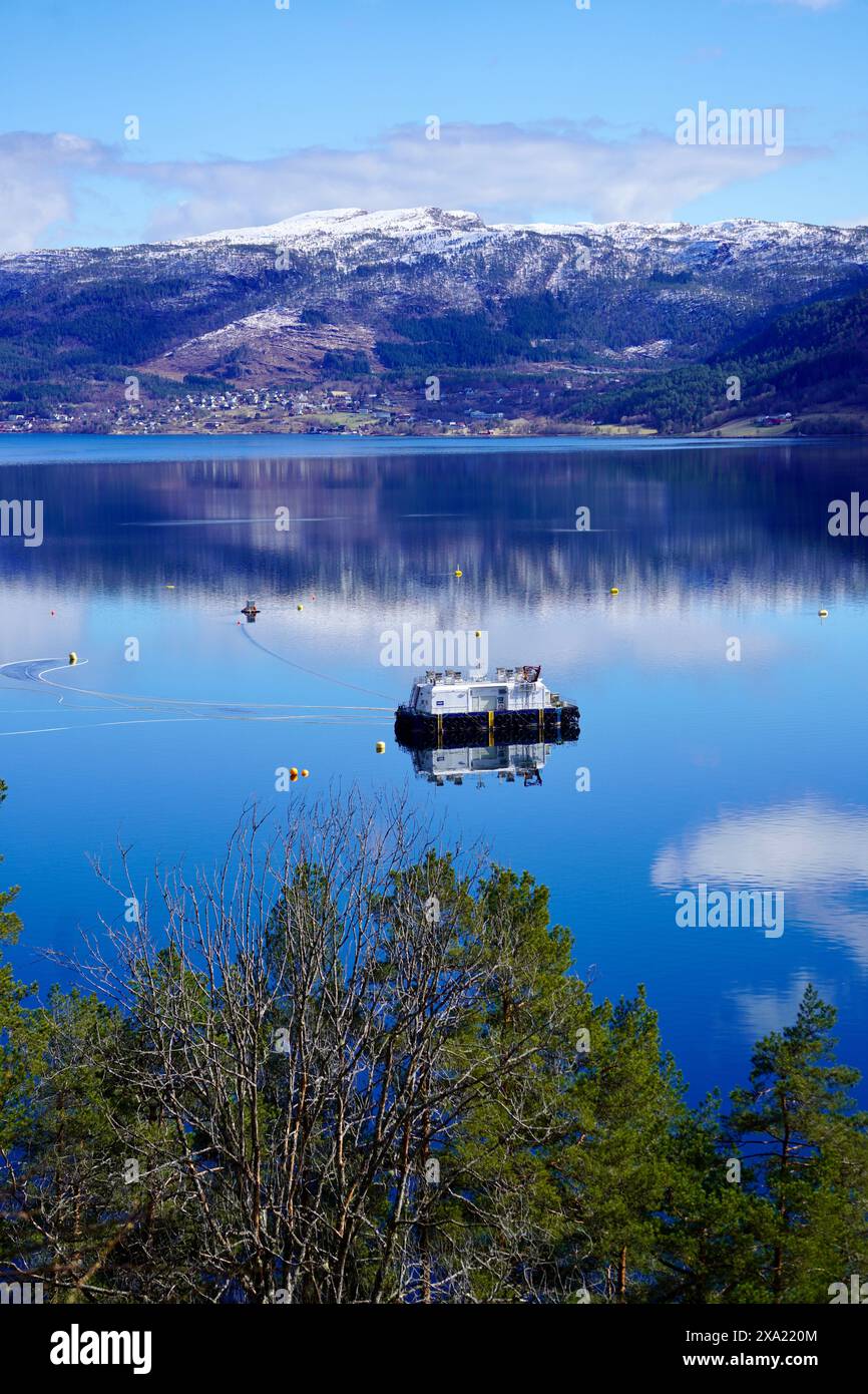 Une ferme piscicole sur les eaux sereines d'un fjord norvégien près d'Angvik, Norvège Banque D'Images