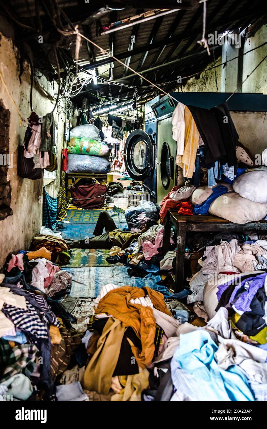 Une pile de vêtements désordonnée sur le sol dans un vieux bâtiment étroit Banque D'Images