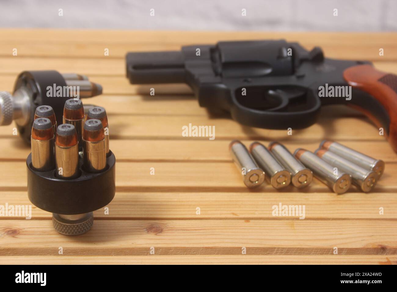 Un pistolet et des balles sur une table en bois Banque D'Images