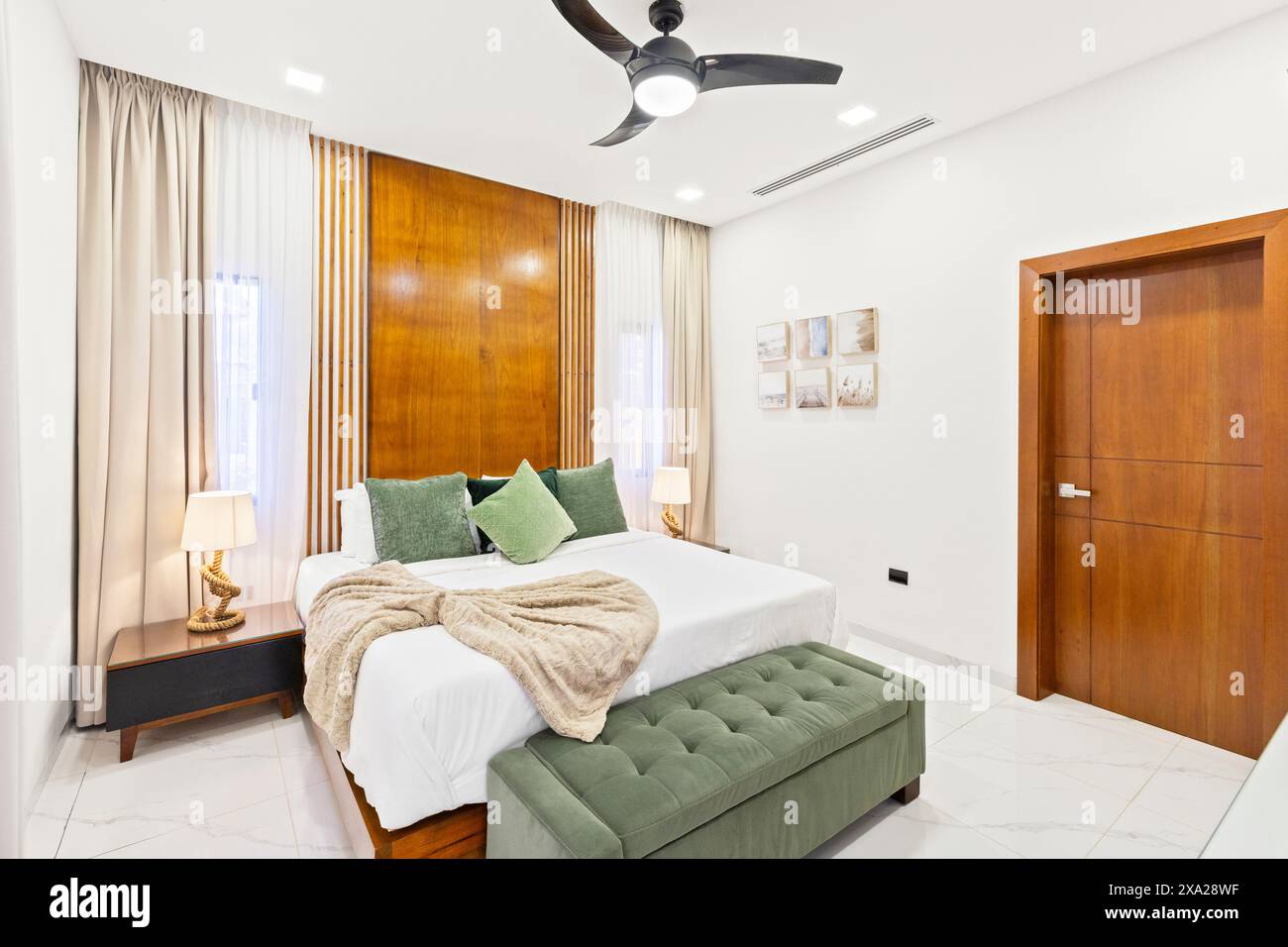 Une chambre avec des accents de mur et de plafond en bois, dotée d''un ventilateur suspendu Banque D'Images