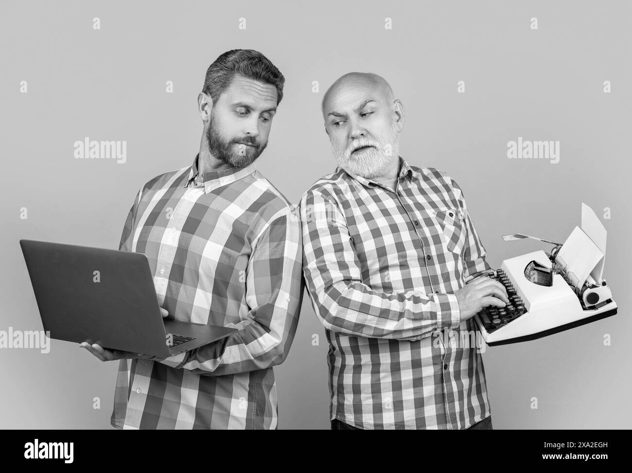 image des hommes montrer contre nostalgie avec ordinateur portable et machine à écrire rétro. Banque D'Images