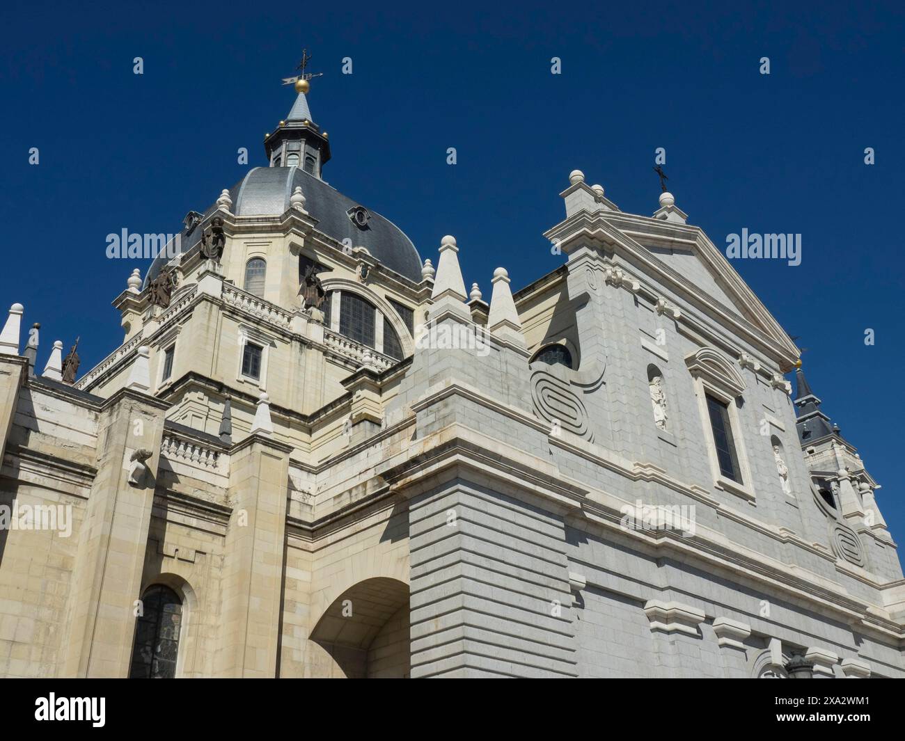 Vue latérale d'une cathédrale avec un dôme imposant et une beauté architecturale sous un ciel dégagé, Madrid, Espagne Banque D'Images Vue latérale d'une cathédrale avec un dôme imposant et une beauté architecturale sous un ciel dégagé, Madrid, Espagne Banque D'Images