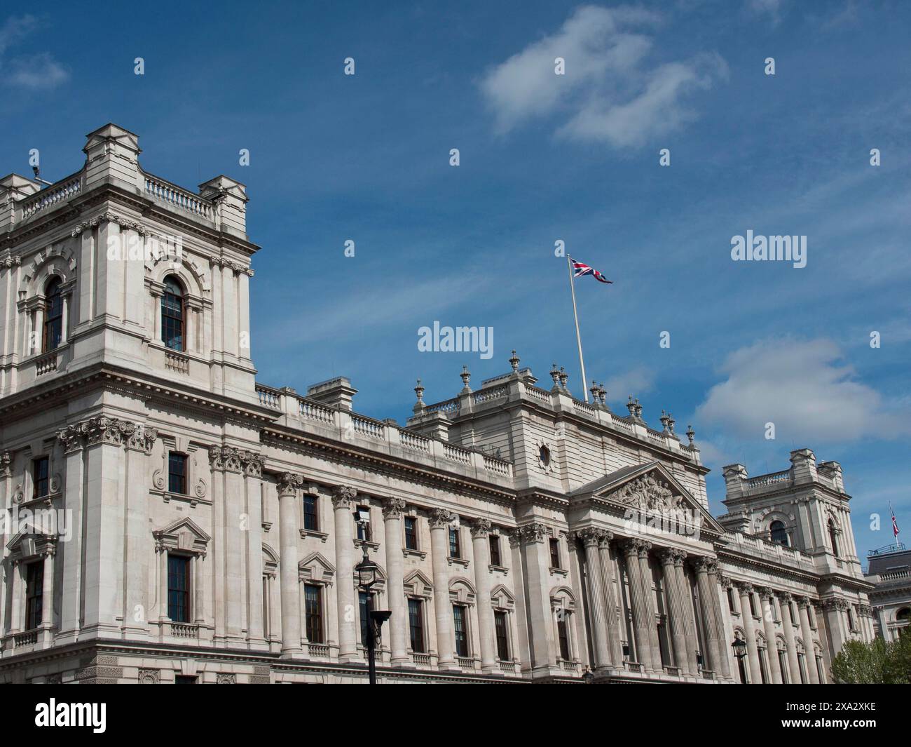 Grand bâtiment historique avec un drapeau de l'Union Jack agitant sur le toit, contre un ciel nuageux, Londres, Angleterre, Royaume-Uni Banque D'Images