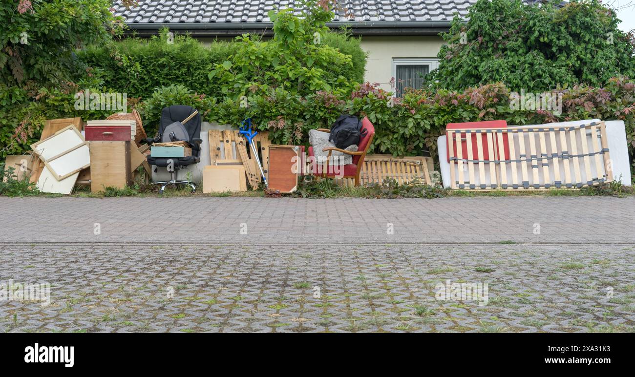 Pile de déchets encombrants sur le bord de la route avec des meubles en bois, des tiroirs, un panier à linge et un sommier à lattes Banque D'Images