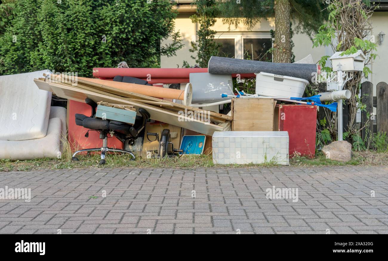 Pile de déchets encombrants sur le bord de la route avec des meubles en bois, des tiroirs et un panier à linge Banque D'Images