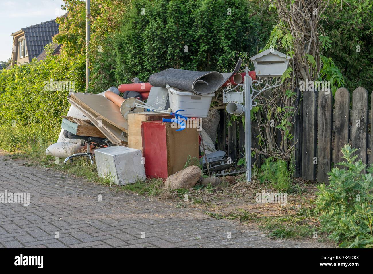 Pile de déchets encombrants sur le bord de la route avec des meubles en bois, des tiroirs et un panier à linge Banque D'Images
