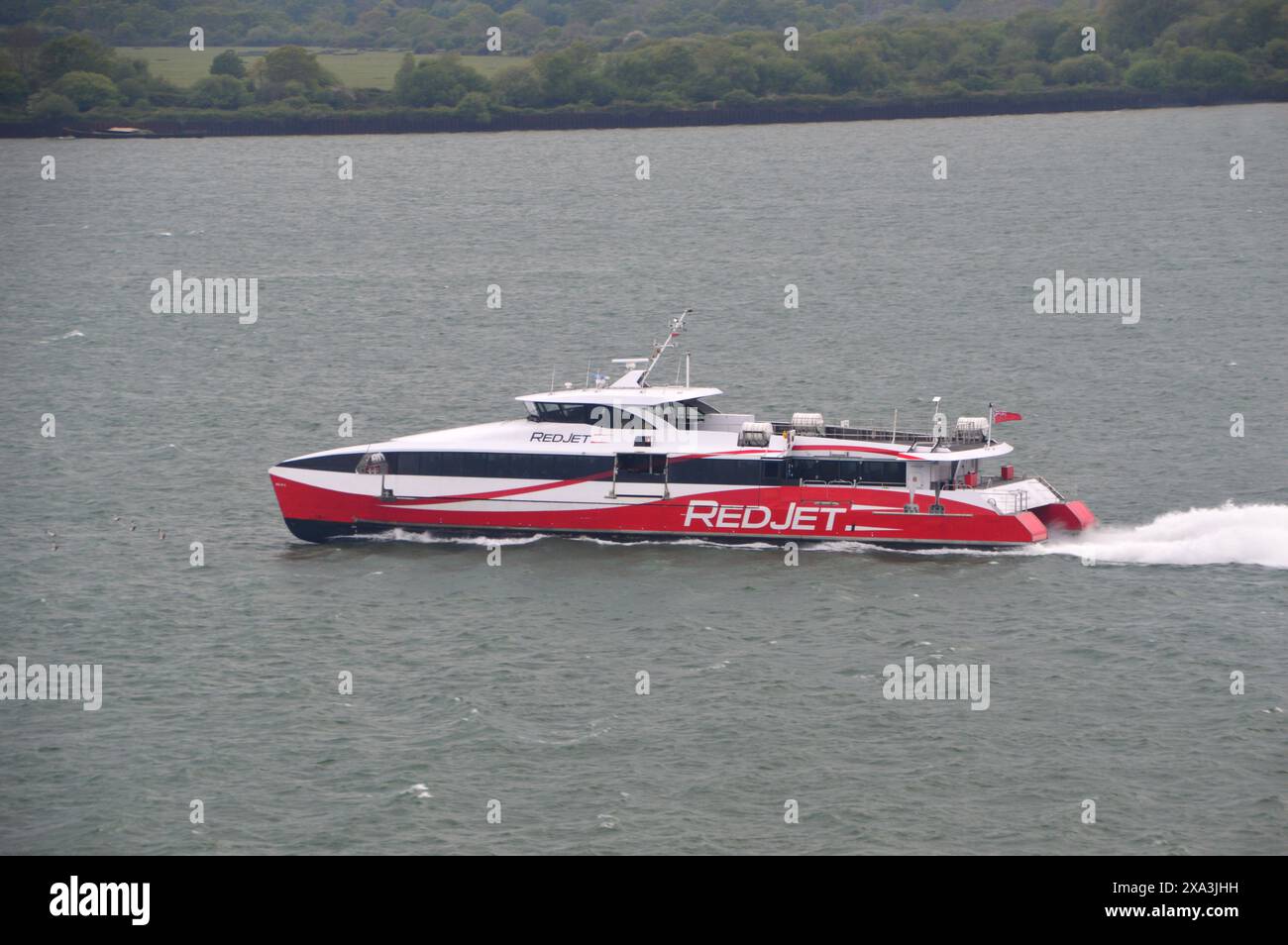 Le Red Funnel Hi-Speed Catamaran Passenger Ferry 'Red Jet 6' naviguant sur le Solent à Southampton depuis l'île de Wight, Hampshire, Angleterre, Royaume-Uni. Banque D'Images