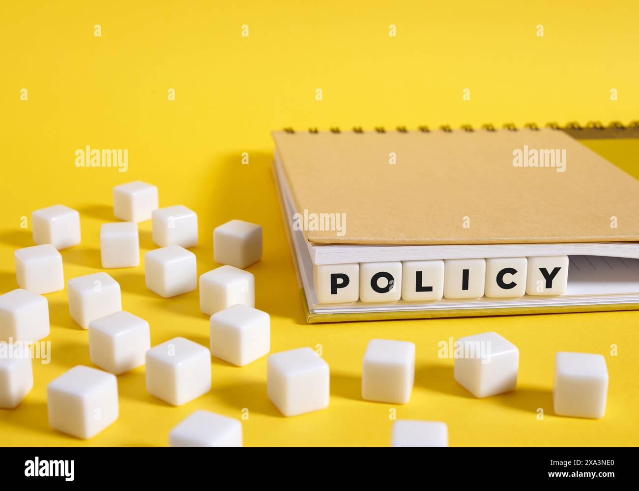 Le mot Policy écrit sur des cubes dans un cahier sur fond jaune. Concept de formation des politiques. Banque D'Images