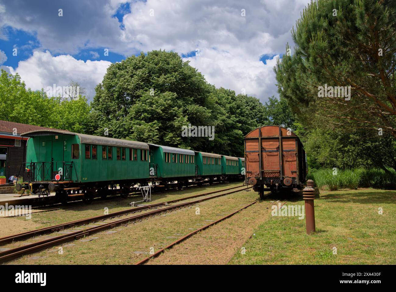 2 trains dans une ancienne gare avec de vieilles voitures vertes et brunes Banque D'Images