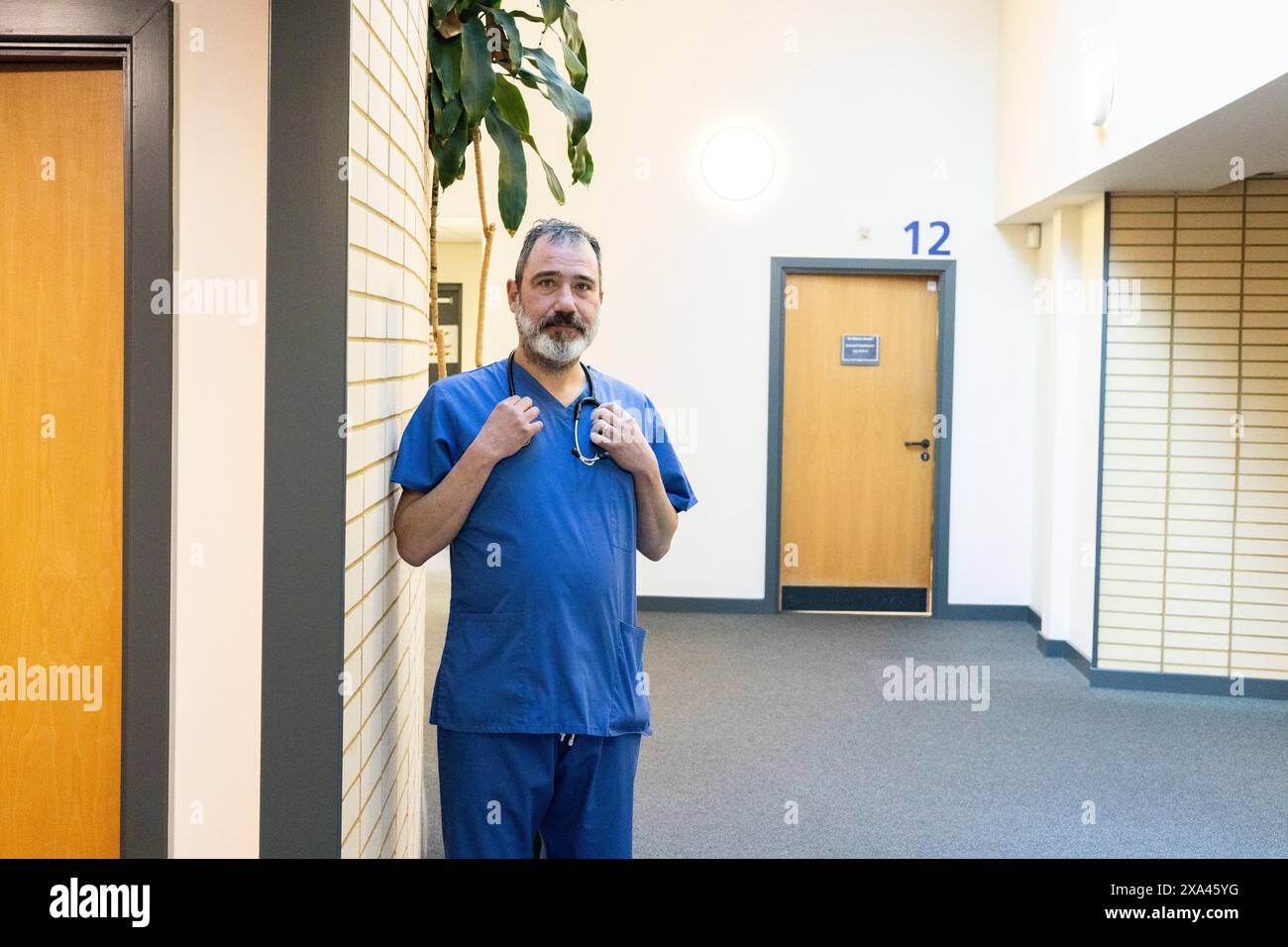 Docteur en gommages bleus debout dans le couloir de l'hôpital Banque D'Images