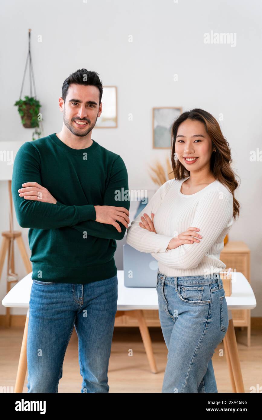 Deux adultes souriants debout avec confiance, les bras croisés Banque D'Images