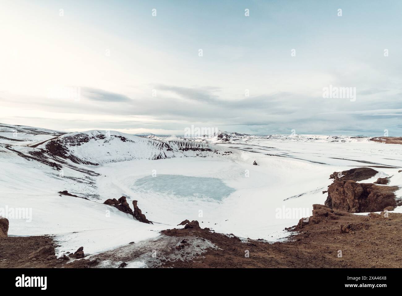 Lac gelé dans un paysage enneigé avec un ciel clair. Banque D'Images