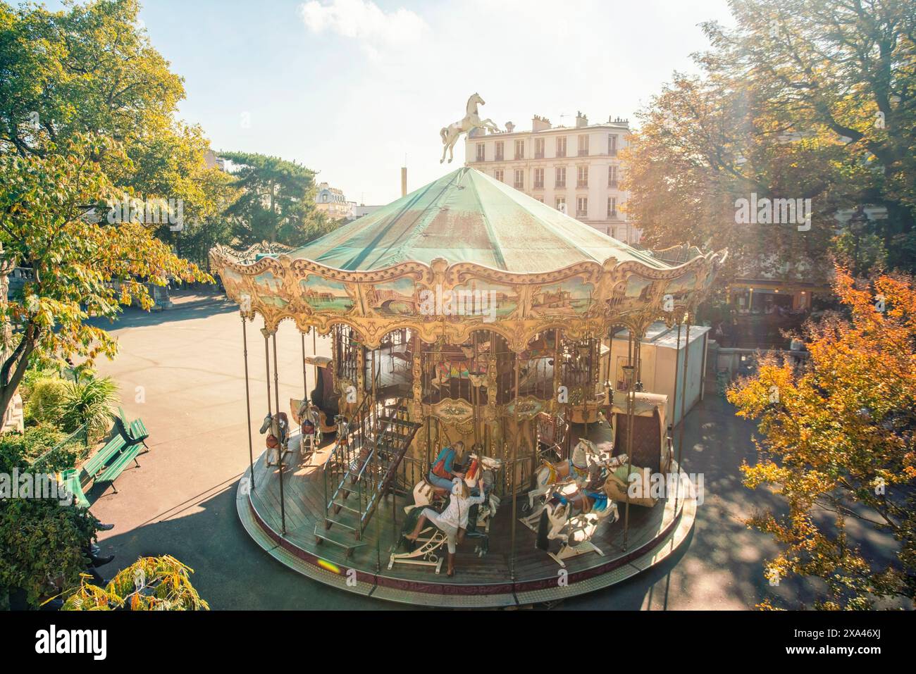 Carrousel vintage ensoleillé dans un cadre de parc tranquille. Banque D'Images