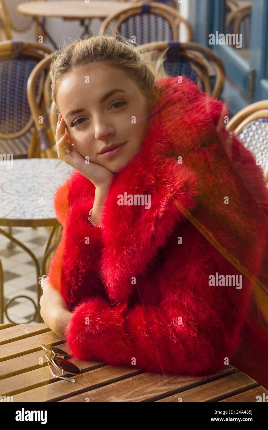 Femme au Red Fake fourrure Coat assis au café extérieur Banque D'Images