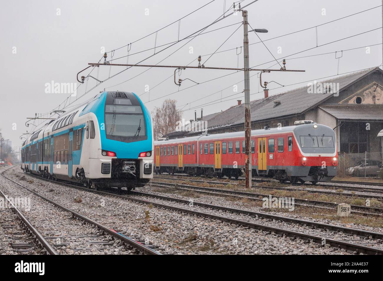 Anciens et nouveaux trains de voyageurs sur les voies ferrées adjacentes. L'ancienne place pour le nouveau dans le transport ferroviaire. Banque D'Images