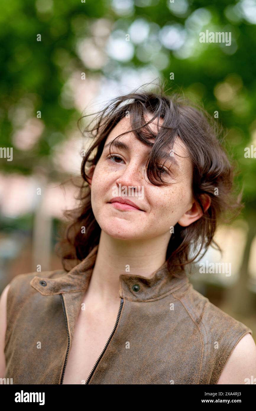 Jeune femme confiante avec une expression joyeuse debout à l'extérieur. Banque D'Images