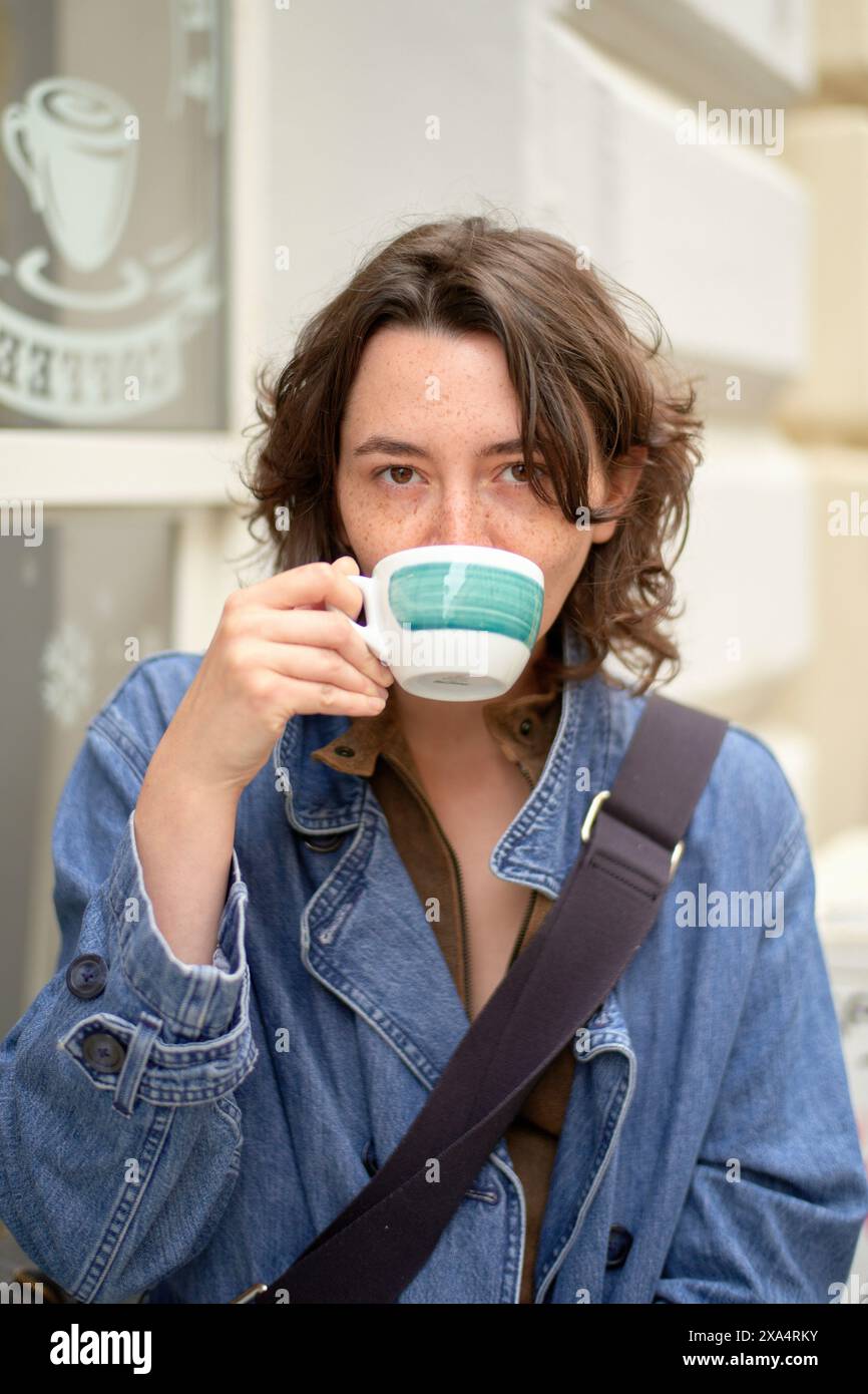Femme profitant d'une tasse de café dans un café en plein air Banque D'Images
