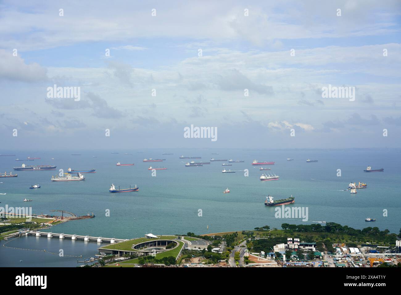 Vue aérienne d'une voie maritime très fréquentée avec de nombreux cargos près d'une ville côtière par temps couvert. Banque D'Images