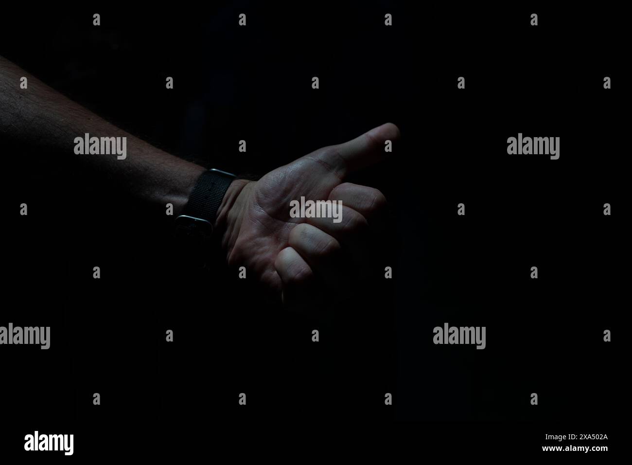 Soyez positif. Main humaine avec Thumbs-Up dans l'obscurité. Banque D'Images