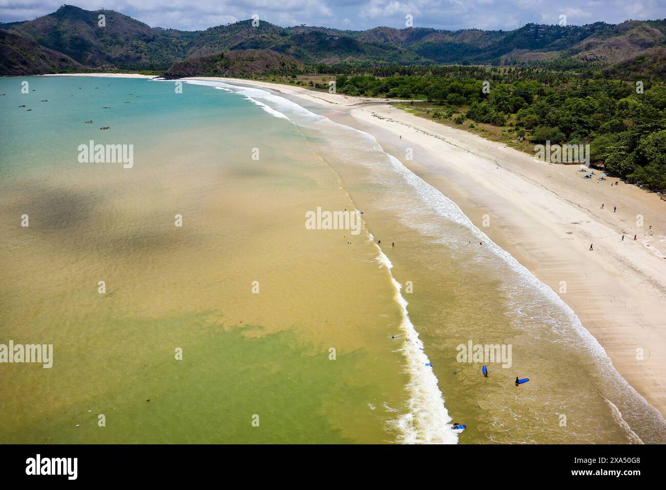 Surfeurs sur la plage et dans l'océan à Selong Belanak, Lombok, Indonésie Banque D'Images