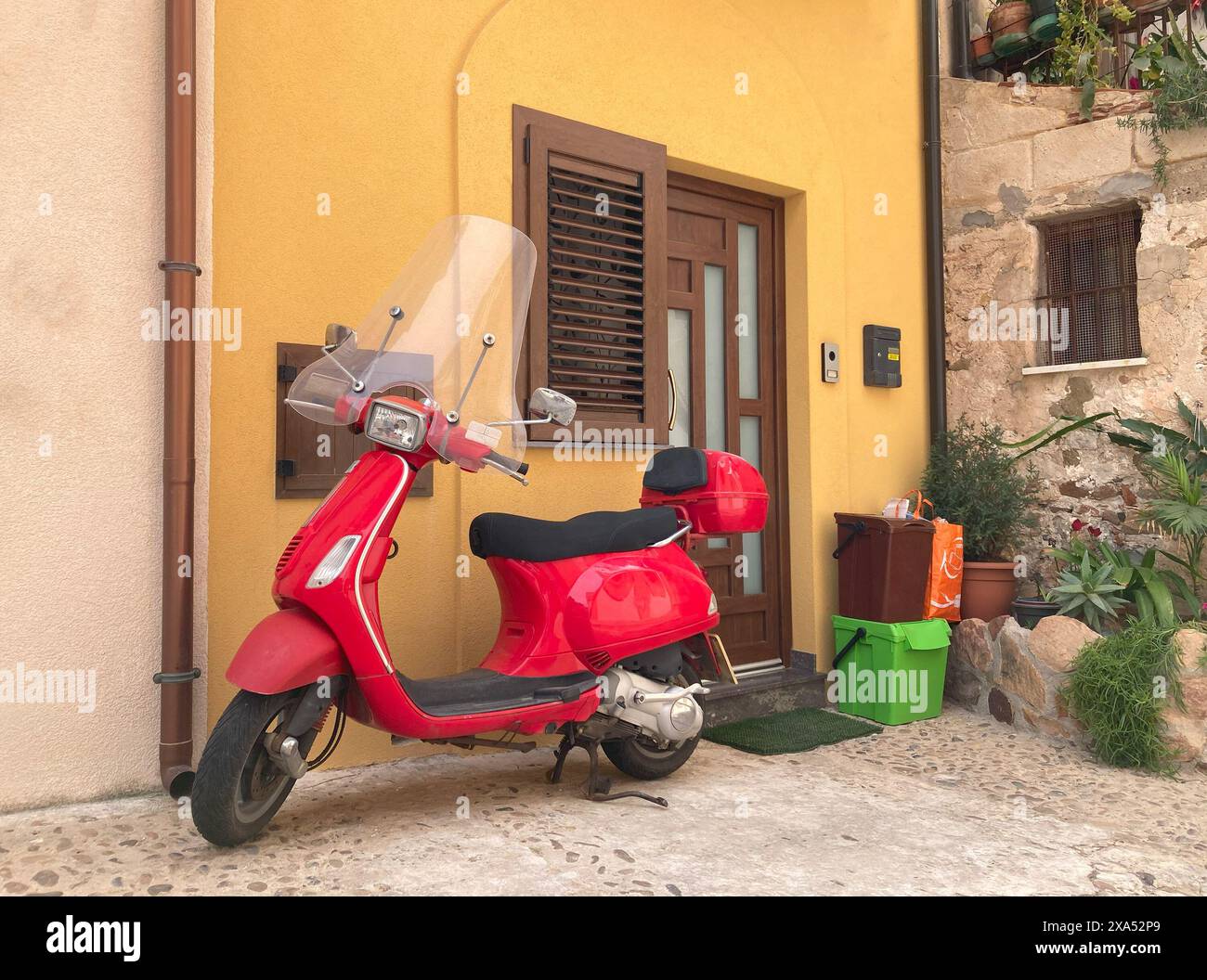 Cyclomoteur rouge se dresse à l'entrée de la maison sur la rue Cefalu Banque D'Images