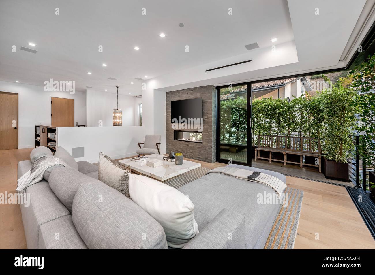 Salon spacieux avec grand canapé et plusieurs tables Banque D'Images