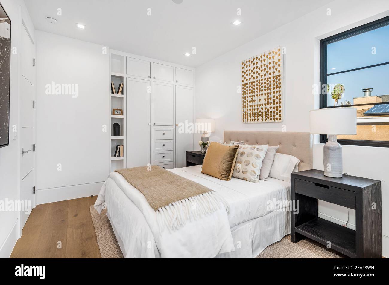 Chambre élégante avec murs blancs, parquet et élégante literie blanche Banque D'Images
