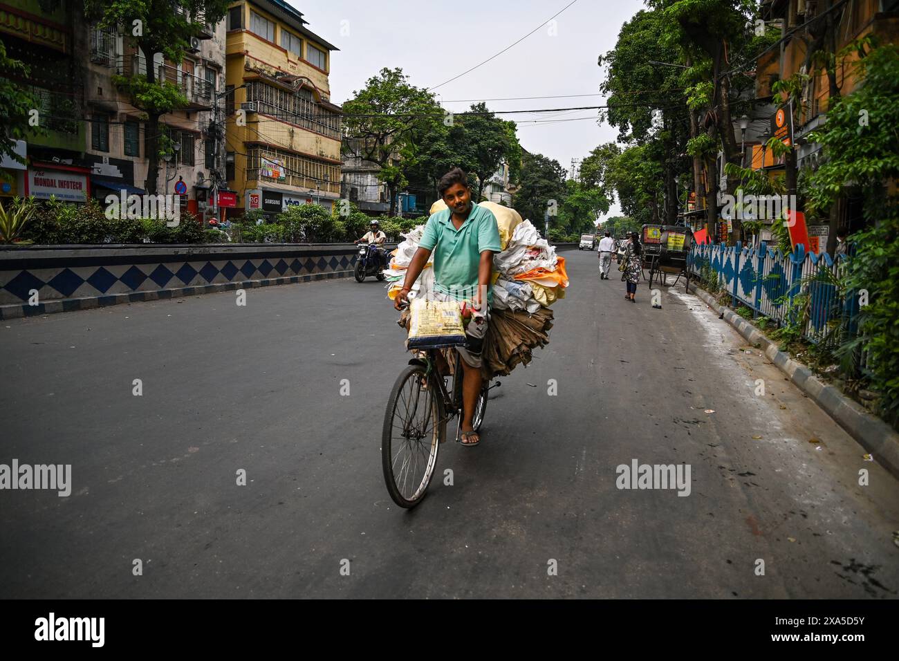 Kolkata, Inde. 3 juin 2024. Un homme vu rouler à vélo tout en transportant des sacs en plastique avant le dépouillement final des élections générales (Lok-SABHA) en Inde. Banque D'Images