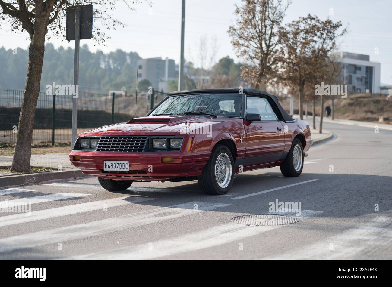 Ford Mustang de la troisième génération, de couleur rouge, c'est une version cabriolet avec un toit en toile rétractable, elle circule dans la rue Banque D'Images