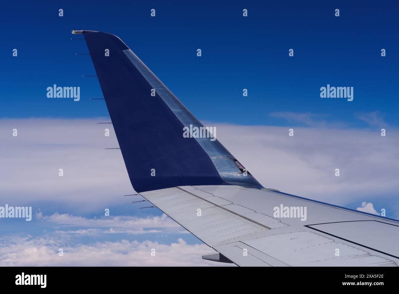 Aile d'avion montrée en vol au-dessus de la Californie du Sud contre les nuages et le ciel bleu. Banque D'Images