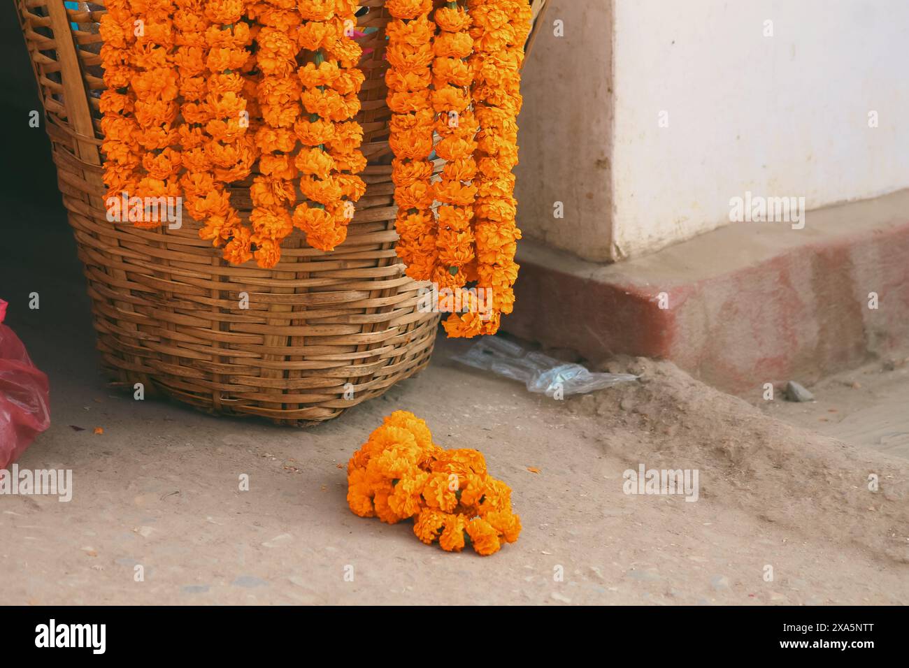 Guirlandes de fleurs de Marigold accrochées sur un panier tissé vide qu'il a utilisé comme offrandes religieuses sacrées qui symbolisent l'abandon à la puissance de Dieu dans la pratique o Banque D'Images