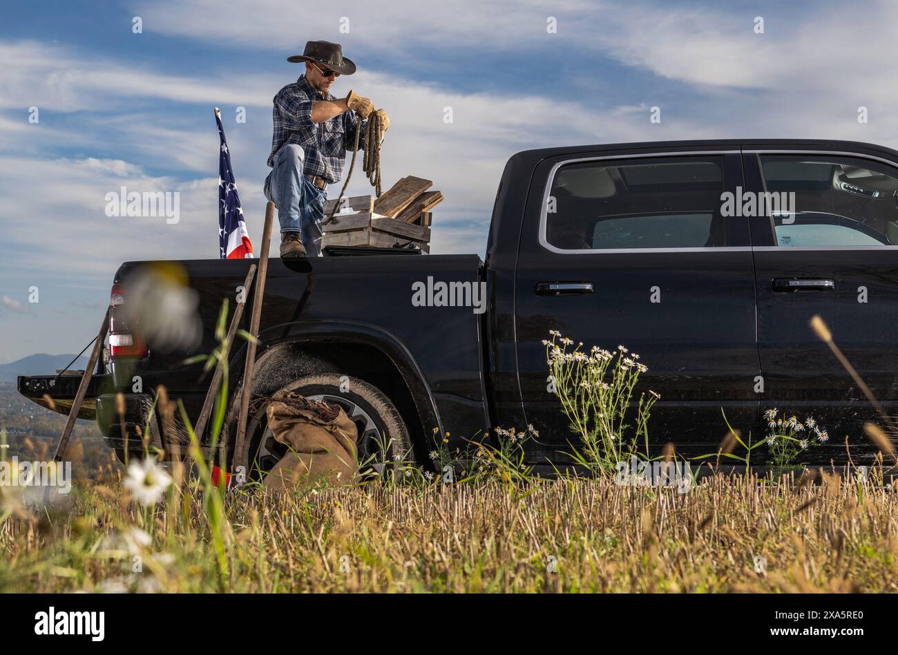 Un Cowboy Rancher préparant des cordes à l'arrière de sa camionnette tout en travaillant sur son Ranch Banque D'Images